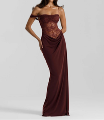 Woman wearing a burgundy evening gown with lace detailing on a light gray background