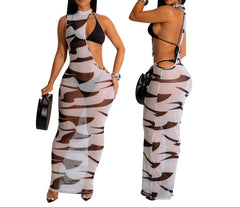 Woman wearing a camouflage jumpsuit with a black top, holding a black handbag.