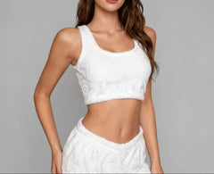 Woman wearing a white sleeveless top and skirt against a gray background