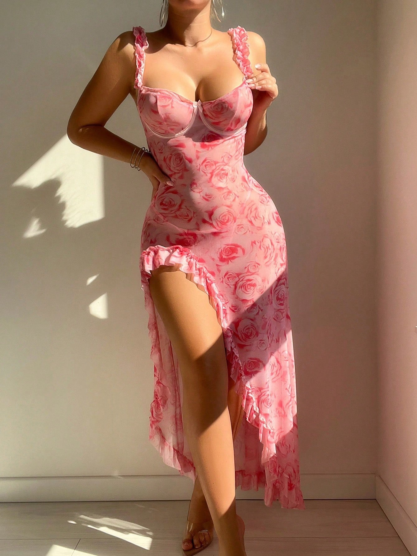 Person wearing a pink floral lace nightgown against a plain wall.
