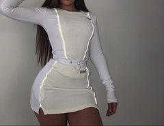 Woman wearing a white crop top and skirt with a visible reflective strip on the skirt. The outfit gives a sporty and casual look.