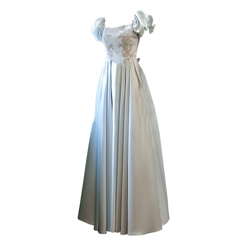 Elegant silver evening gown with floral embellishments on a white background