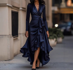 Woman wearing a navy blue dress with ruffles on a city street.