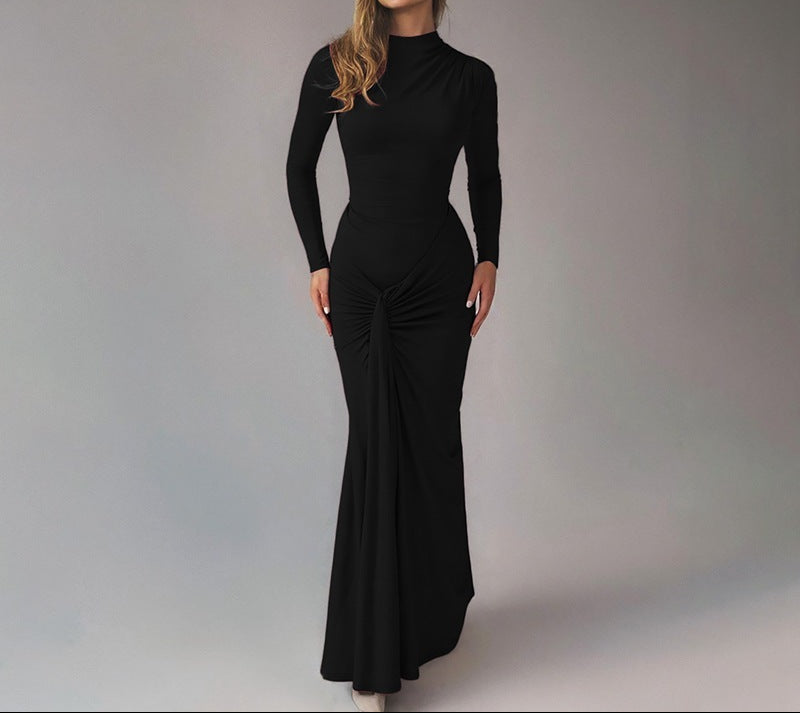 Woman wearing a black jumpsuit against a plain background