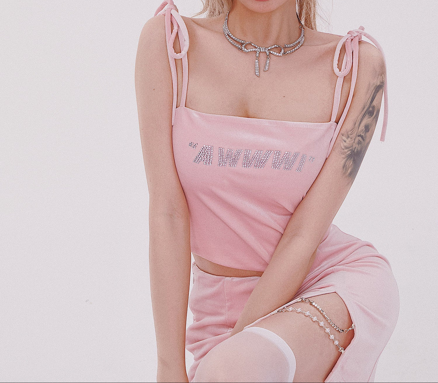 Person wearing a pink outfit with 'MFW' text on a plain background