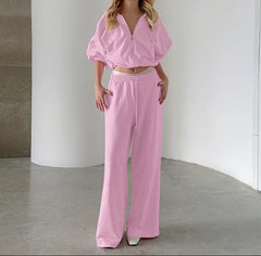 Woman wearing a pink outfit standing against a neutral background