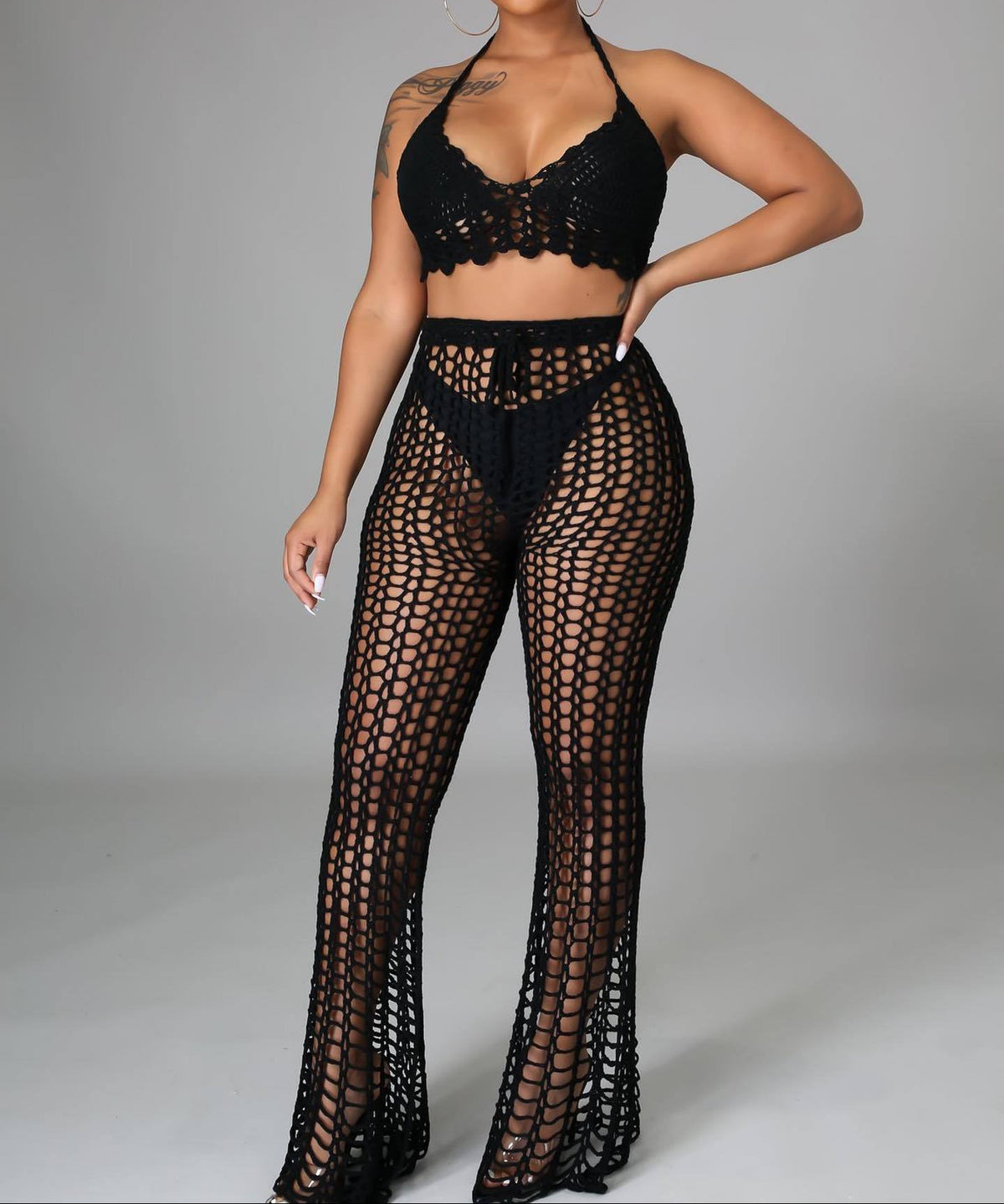 Black crochet outfit on a model against a gray background