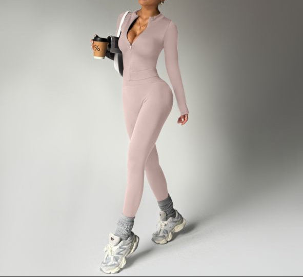 Woman in a pink jumpsuit holding a coffee cup on a gray background
