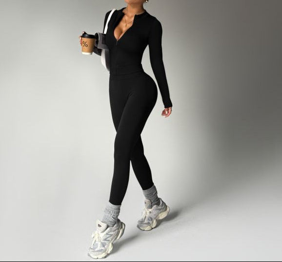 Woman in black athletic outfit holding a coffee cup on a gray background