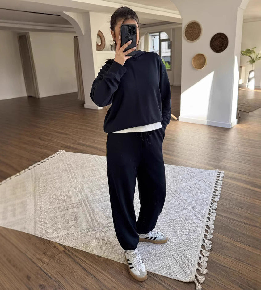 Person taking a mirror selfie in a modern room with wooden flooring and decorative elements.