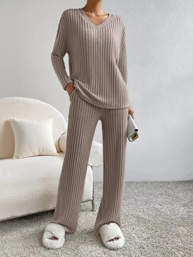 Person wearing a beige ribbed lounge set in a cozy living room.