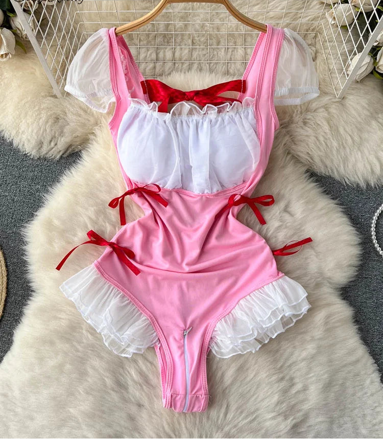Pink and red swimsuit with lace details on a hanger against a textured surface.