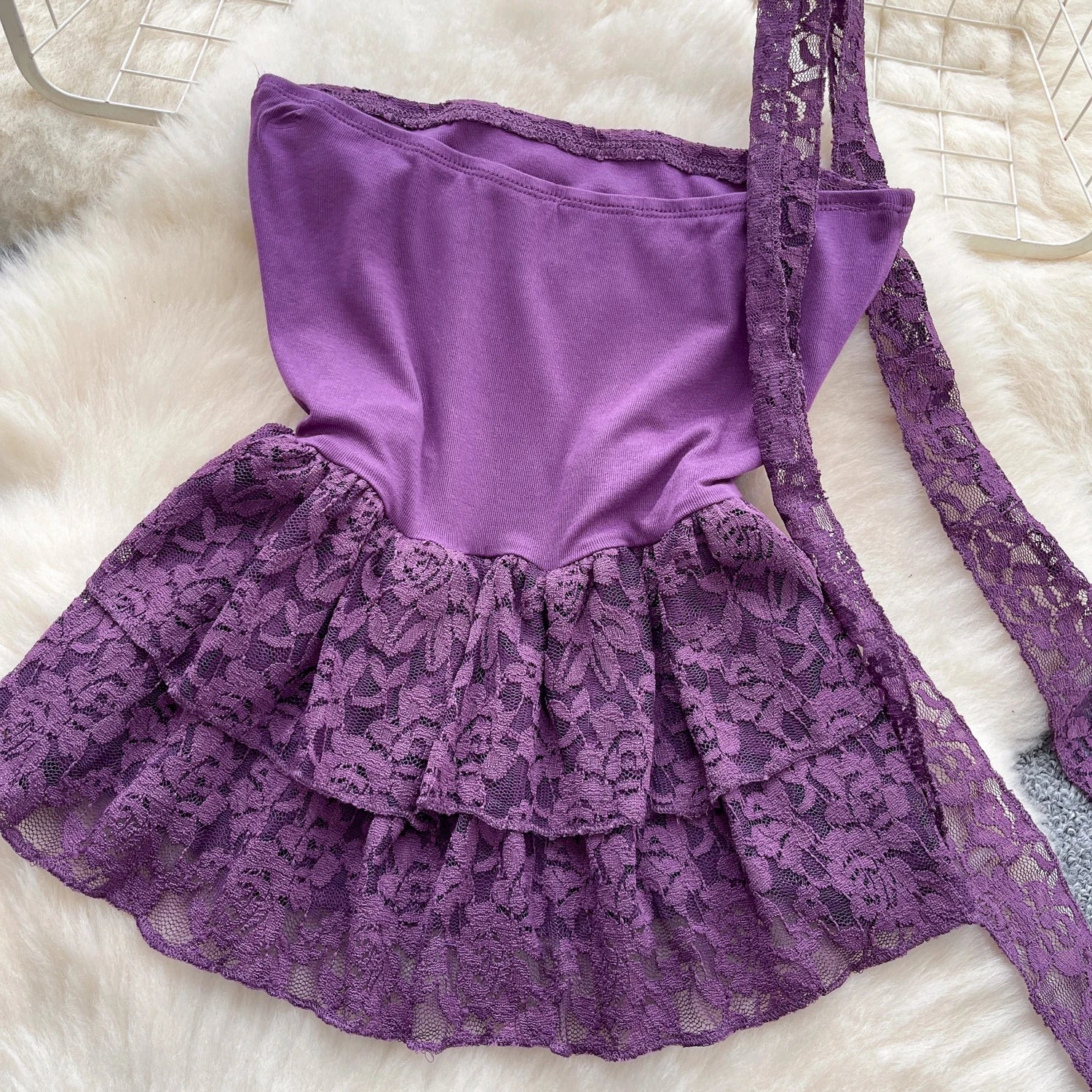 Purple lace dress on a white fur surface