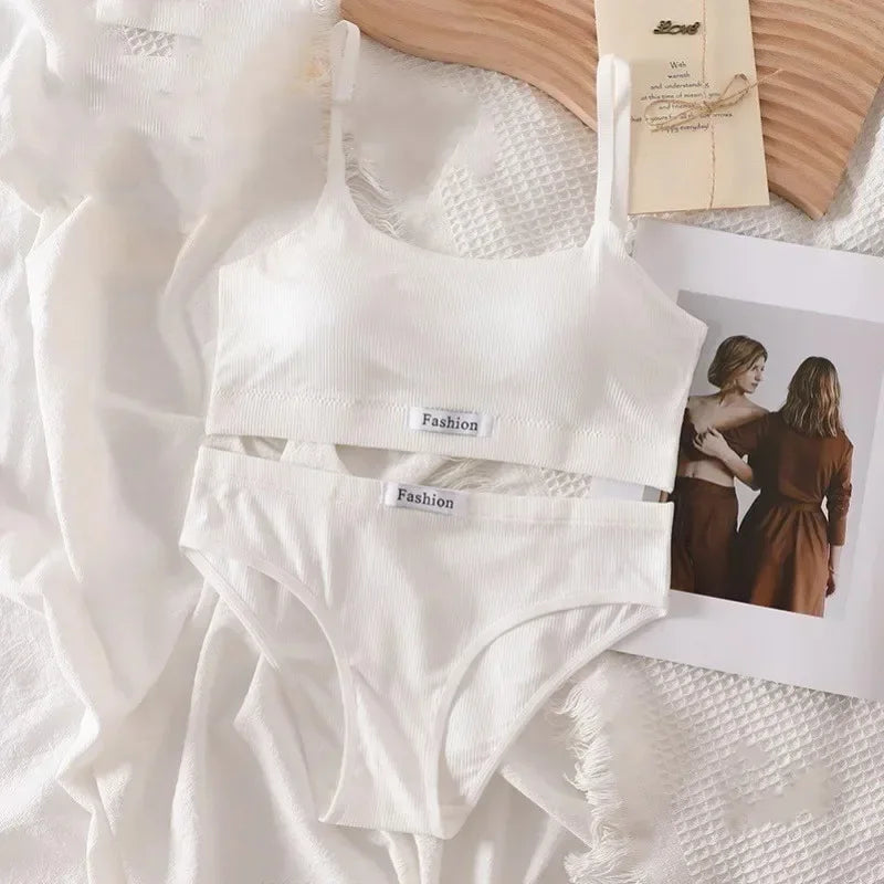 White ribbed bra and panties set with 'Fashion' label on a textured surface.
