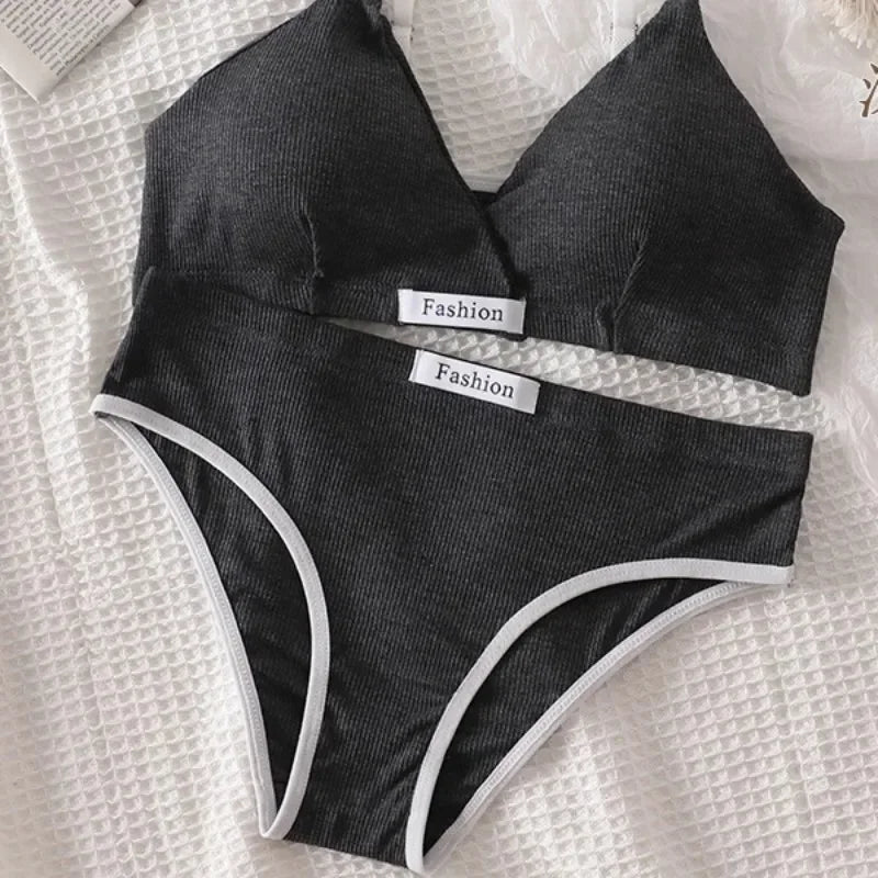 Black bikini set with 'Fashion' labels on a textured white surface