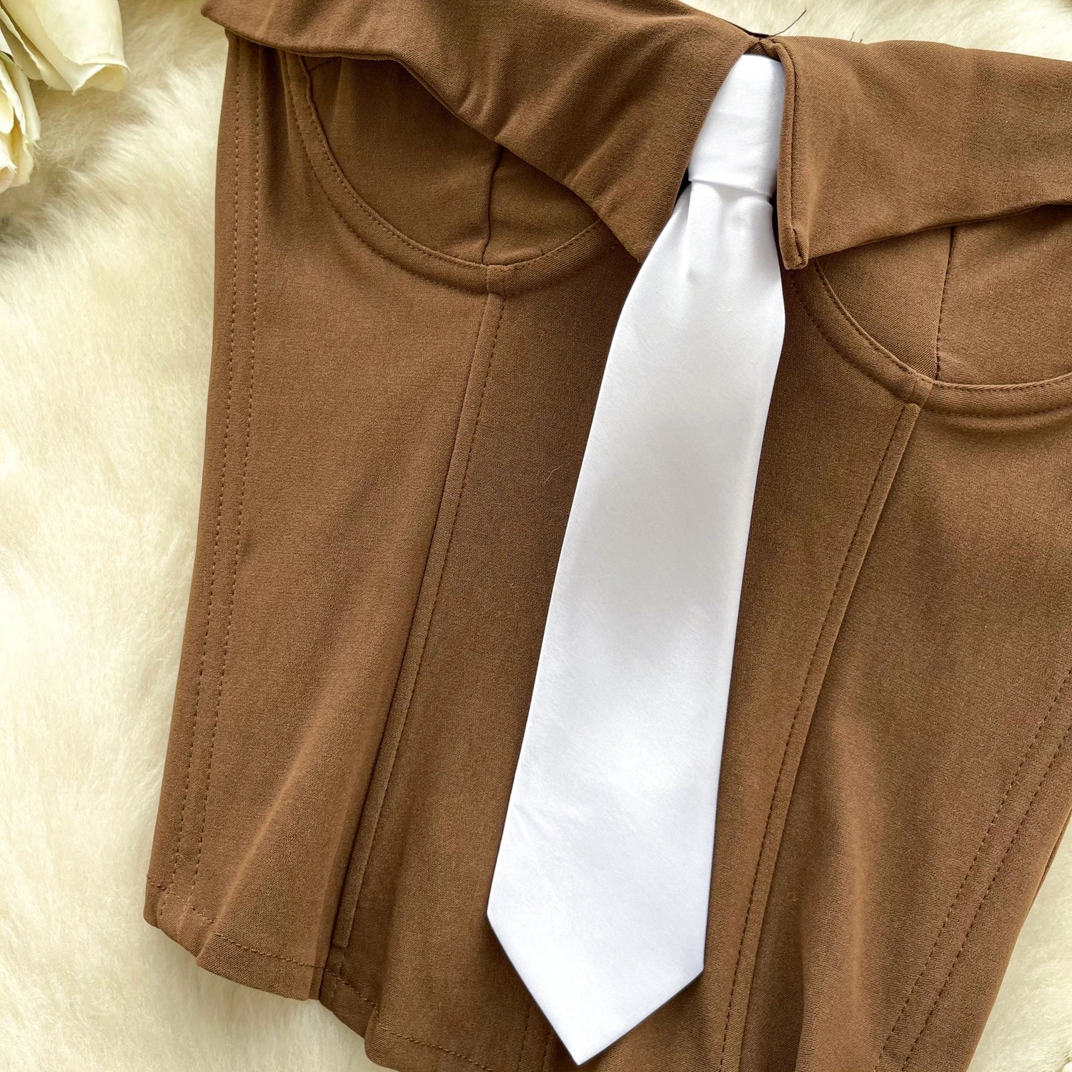 Brown pants with a white tie on a light background