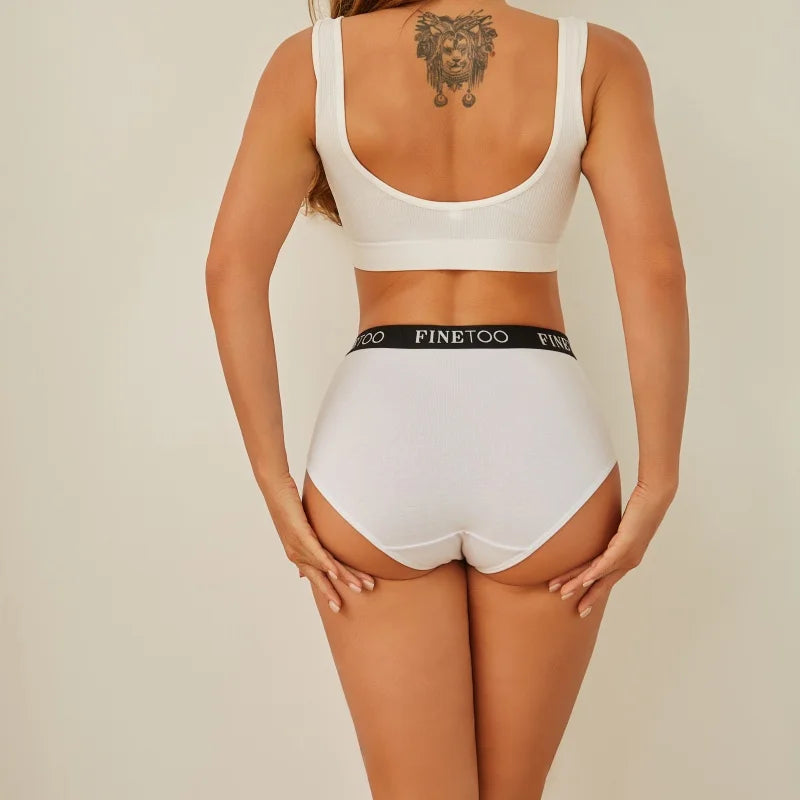 Person wearing a white sports bra and high-waisted underwear with 'FINEtoo' branding on a beige background.