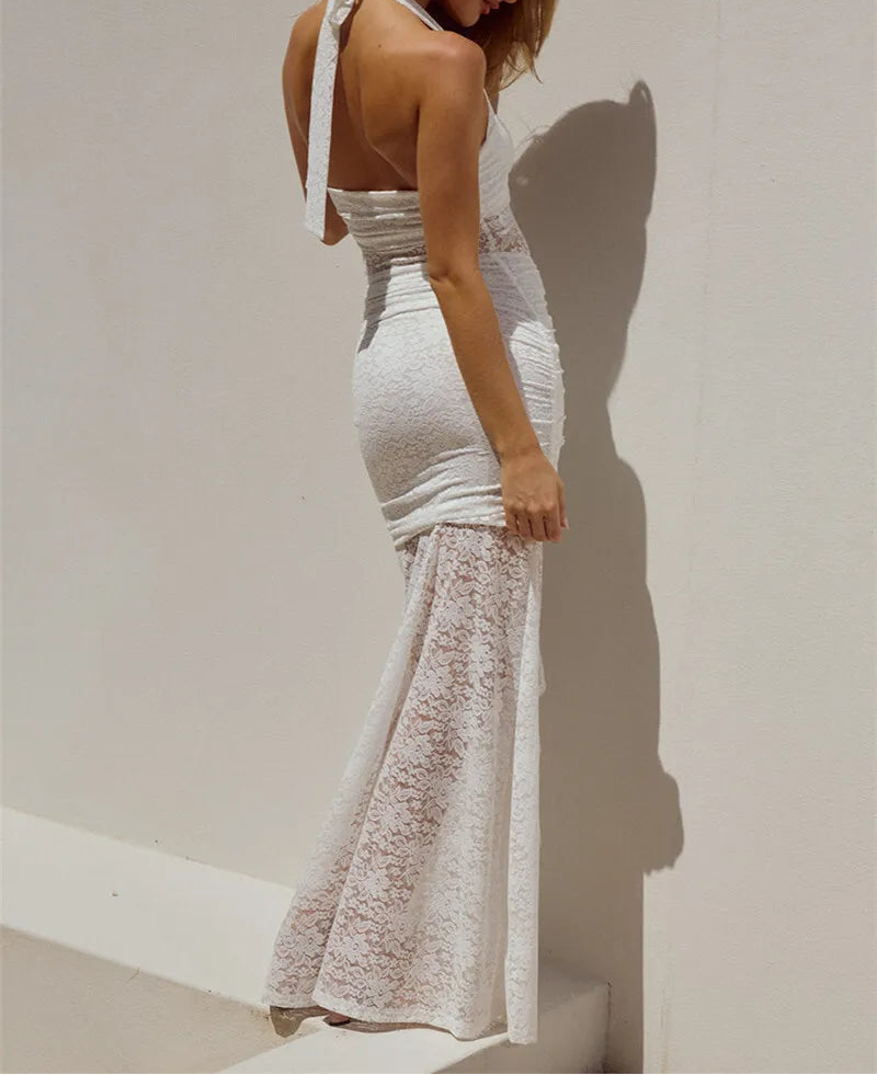 Woman wearing a white lace dress against a plain background
