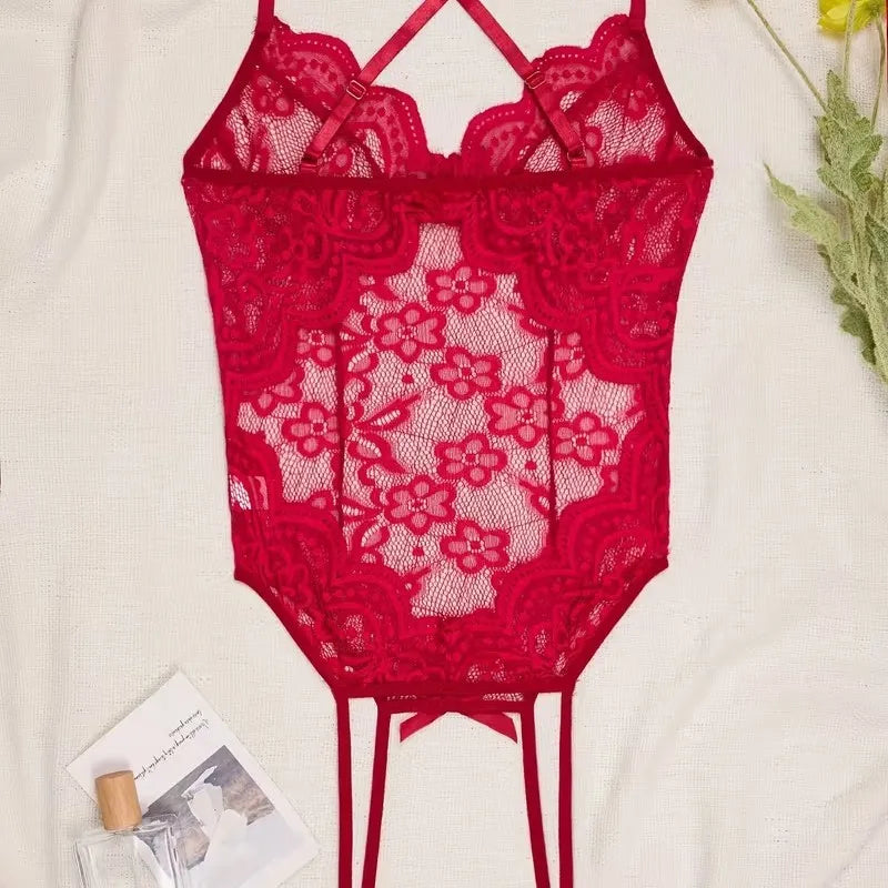 Red lace bodysuit on a light background with a magazine and perfume bottle.