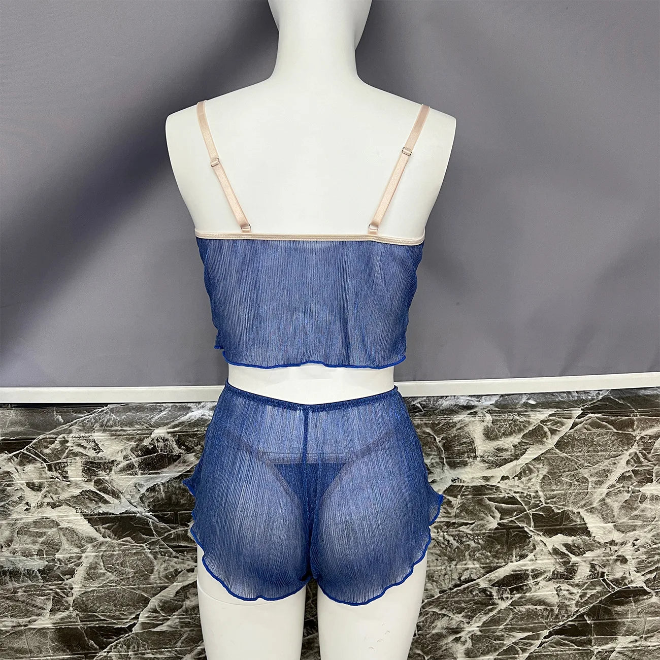 Mannequin wearing a blue sheer outfit against a gray background