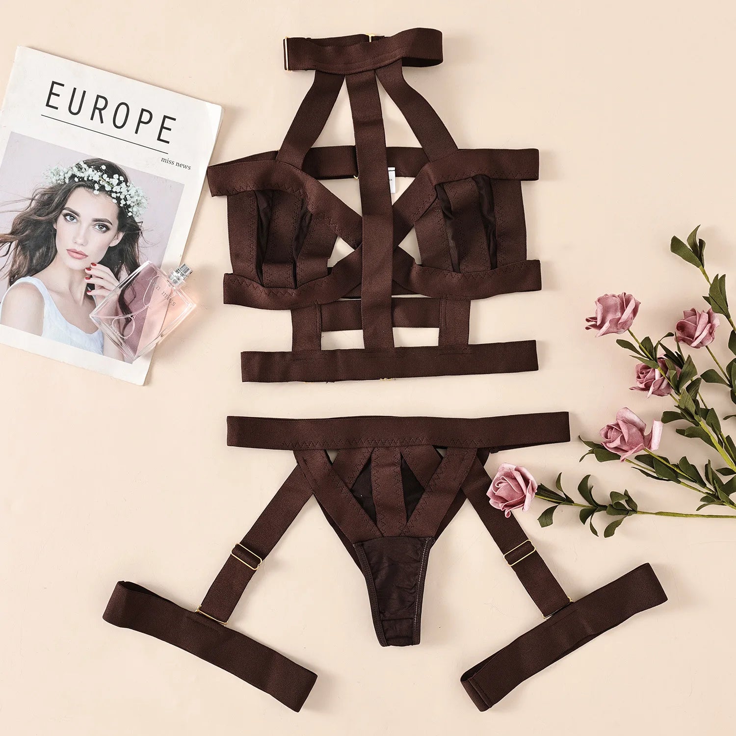 Brown strappy lingerie set on a beige surface with flowers and a magazine.