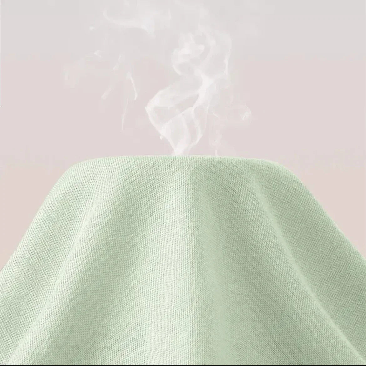 Light green fabric with steam rising from it on a light pink background
