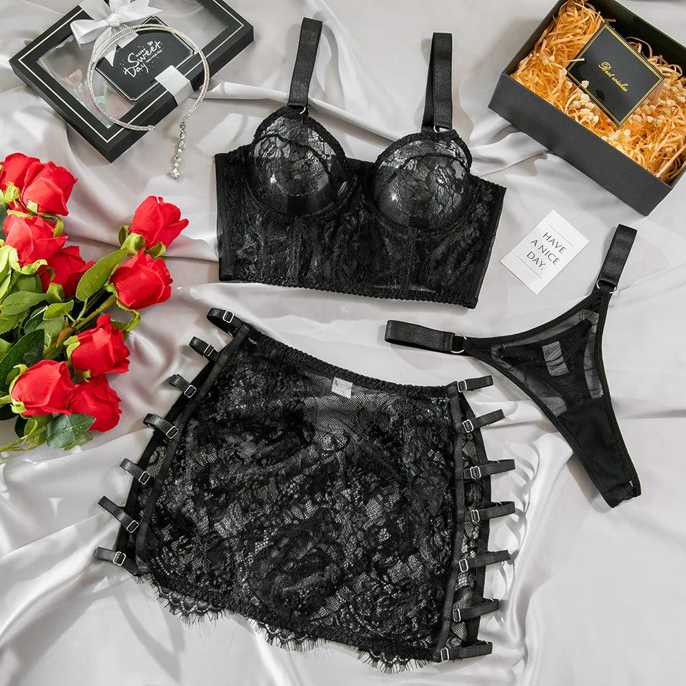 Black lace lingerie set with red roses and gift boxes on a white surface