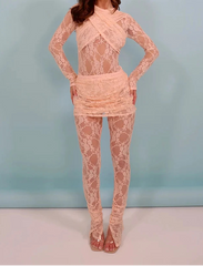 Woman wearing a pink lace outfit against a light blue background