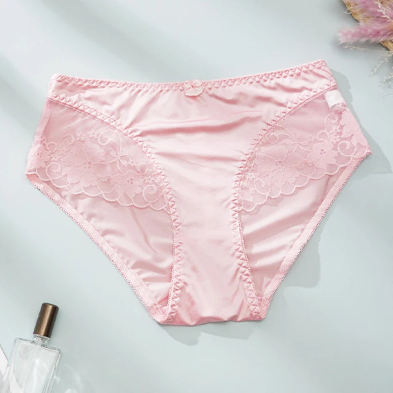 Pink lace-trimmed underwear on a light gray background