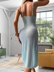 Woman in a light blue dress standing in a modern living room.