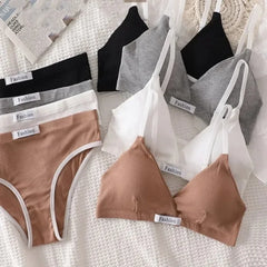 Collection of women's underwear including bras and panties on a textured surface.
