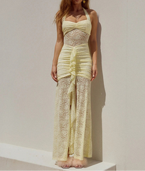 Woman wearing a light yellow lace dress against a plain background