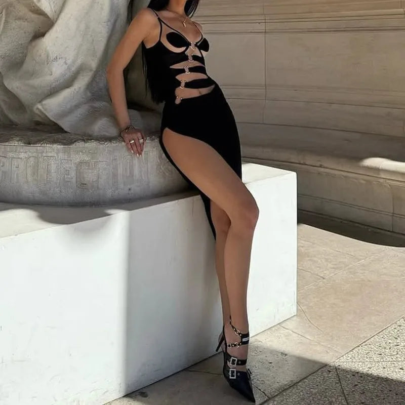Woman in a black dress with cut-out design sitting on a stone bench.