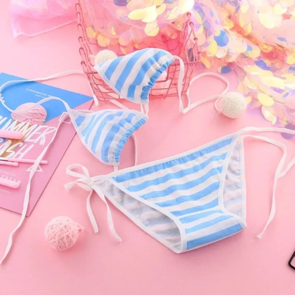Blue and white striped bikini set on a pink background with confetti.