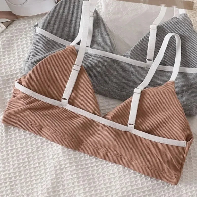Brown bikini top with white straps on a textured surface