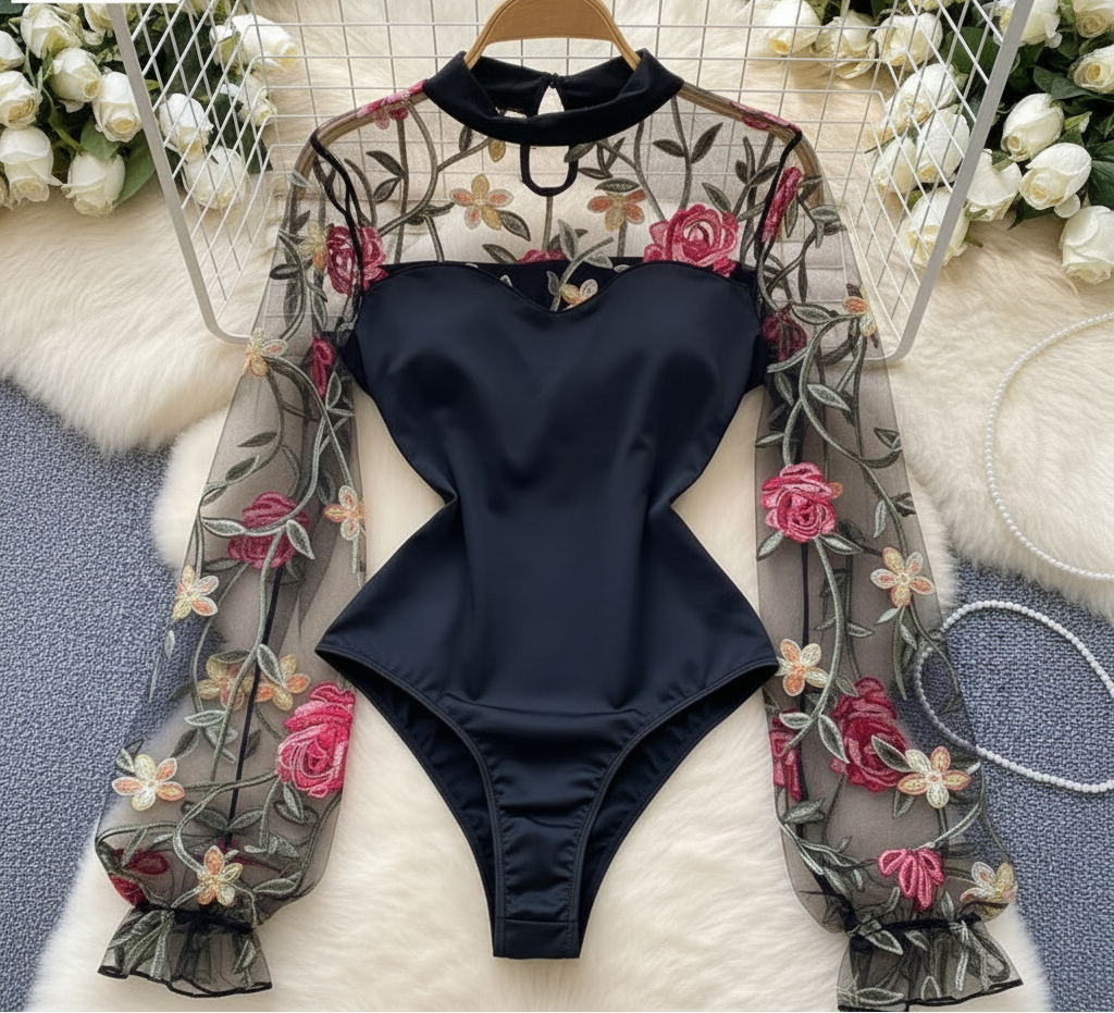 Black swimsuit with floral lace overlay on a white surface