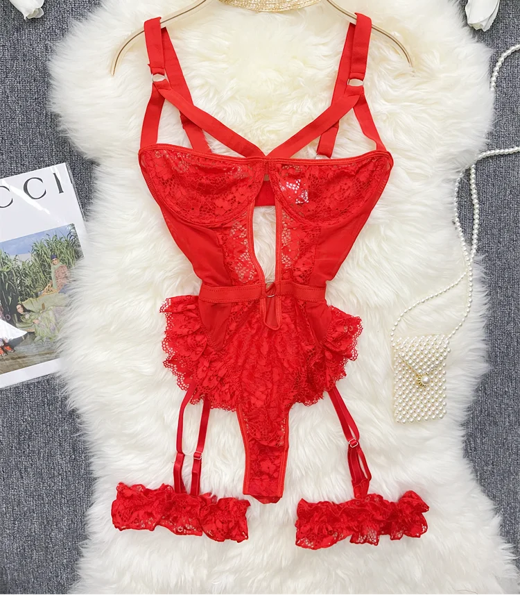 Red lace lingerie set on a hanger with a fluffy white surface and flowers in the background.