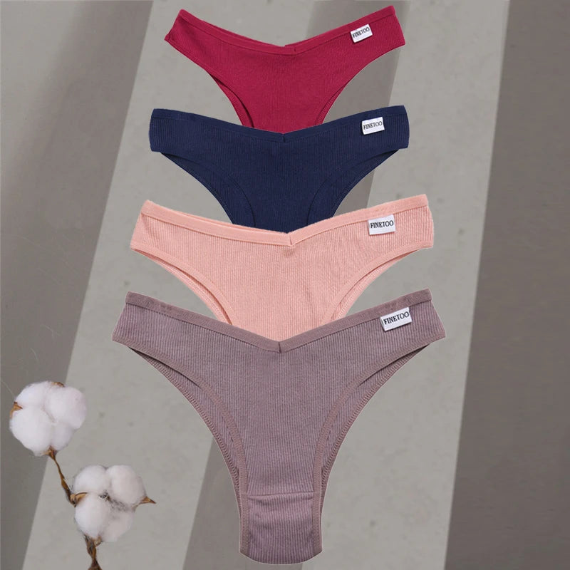 Four pairs of underwear in different colors on a gray background with cotton branches.
