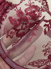 Close-up of red floral lace fabric on a beige background