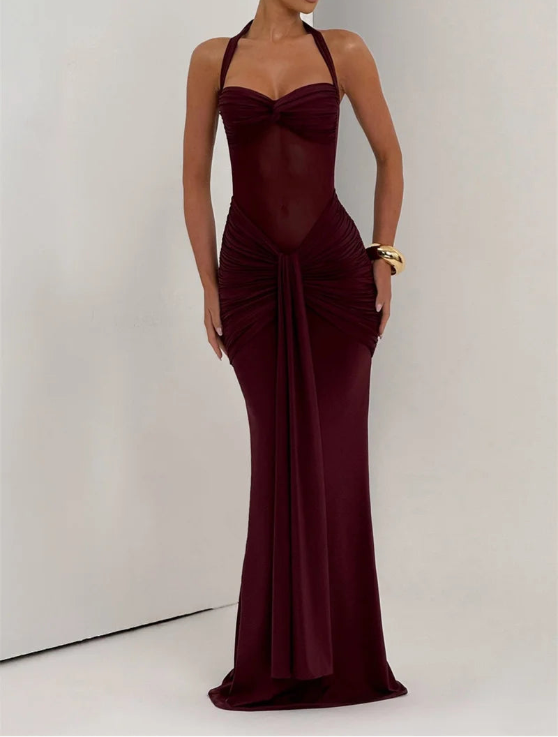 Woman wearing a burgundy evening gown against a plain background