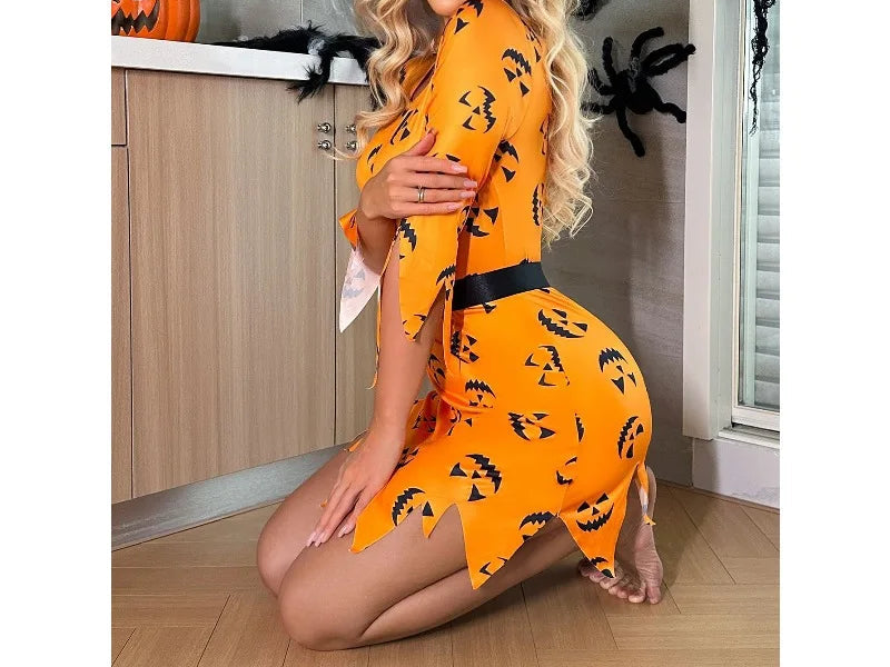 Woman wearing an orange Halloween-themed dress with black patterns in a kitchen.