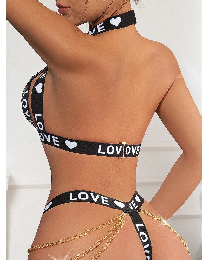 Black 'LOVE' printed bikini set with gold chains on a white background