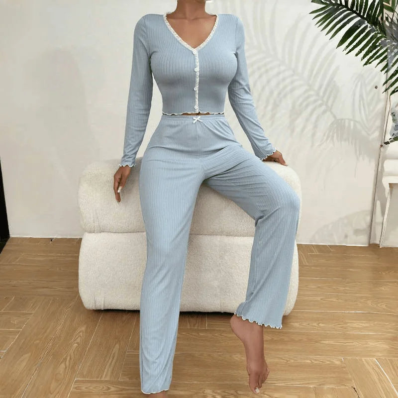 Woman wearing a light blue ribbed lounge set sitting on a white stool.
