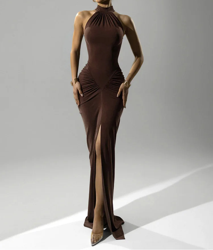 Woman wearing a brown evening gown with a high slit on a gray background