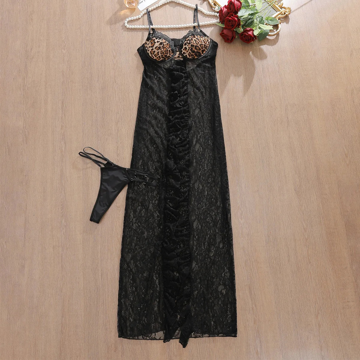 Black lace nightgown with leopard print bralette on a wooden surface.