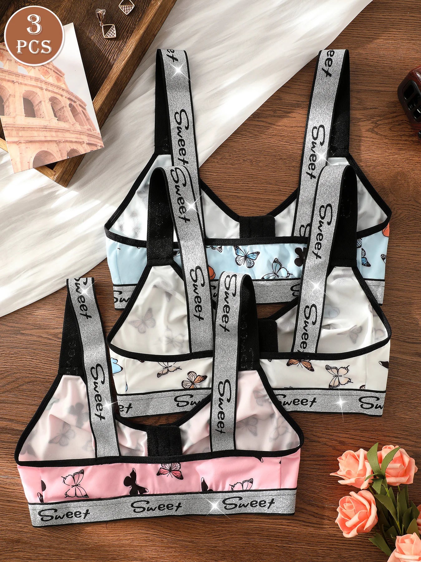 Set of three children's aprons with 'Sweet' branding on a wooden surface.
