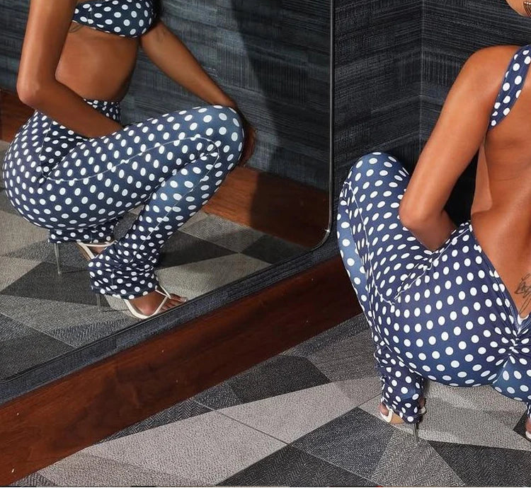 Woman in a polka dot outfit posing in front of a mirror.