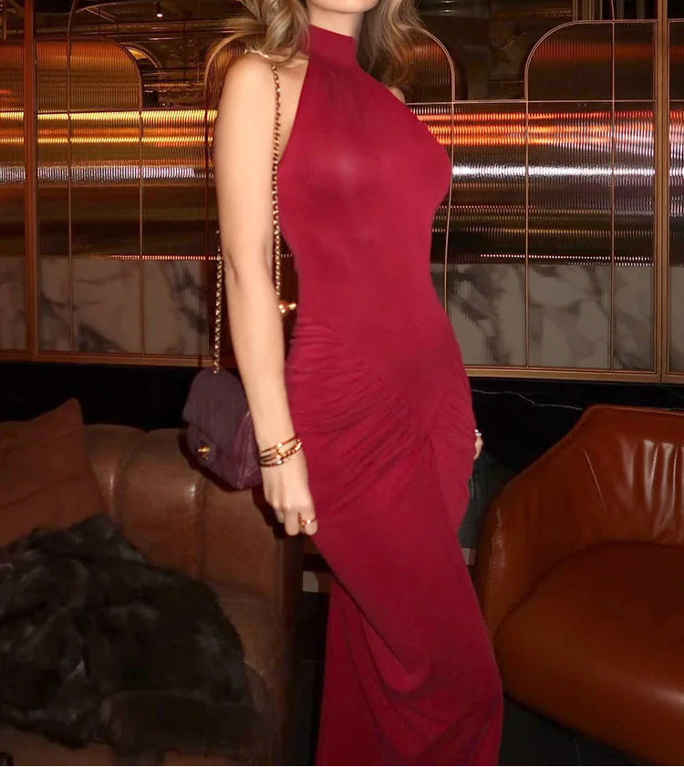 Woman in a red dress and sunglasses in an indoor setting with blurred background