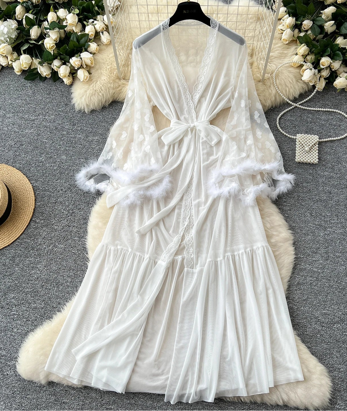 White lace dress on a hanger with decorative elements on a gray surface