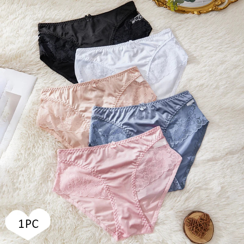 Five pairs of women's underwear in black, white, pink, blue, and pink on a textured surface.